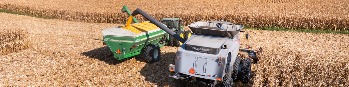 Combine unloads corn into a grain cart during harvest, illustrating the September WASDE crop price outlook.